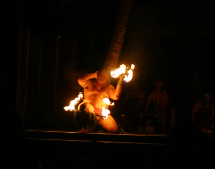 a man holding torches on top of his chest