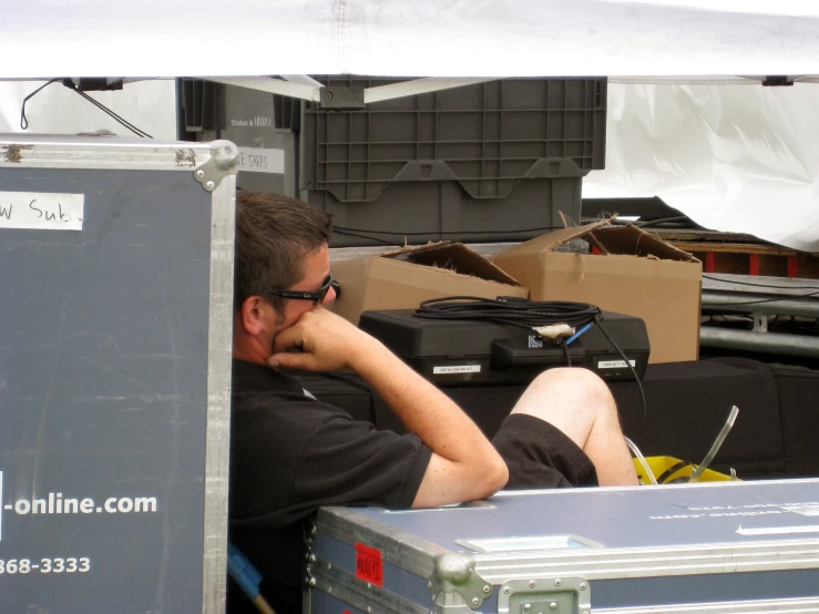 a man sitting in the back of a truck near some boxes