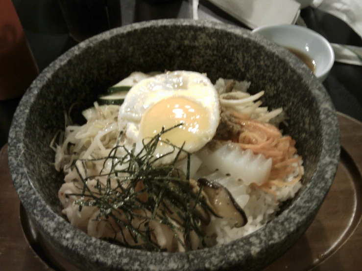 rice, noodles, and an egg served in a bowl on a table