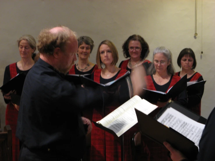 a man in a blue suit sings with other choir members