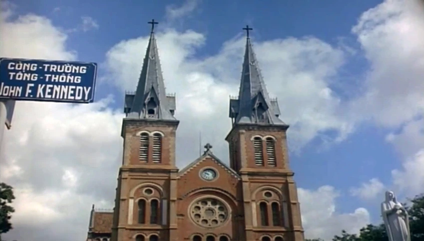 the tall clock tower of a church stands tall against a cloudy sky