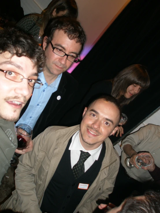 several men in a row drinking wine and smiling