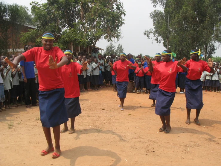 people are dancing in uniforms in front of a crowd