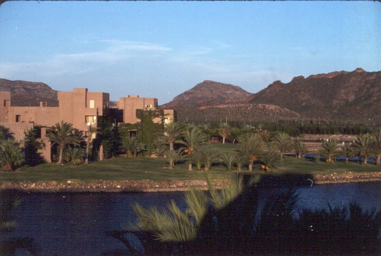 a scenic view of a large building near a river