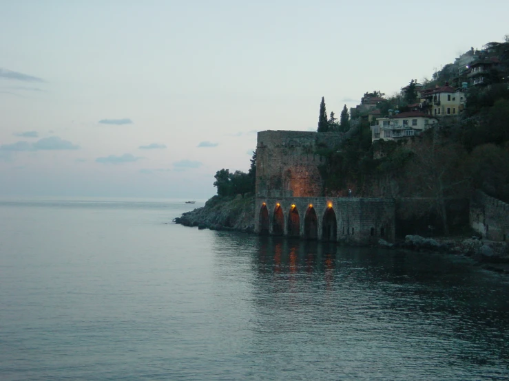 a view of an old castle on a cliff that is in the middle of a body of water