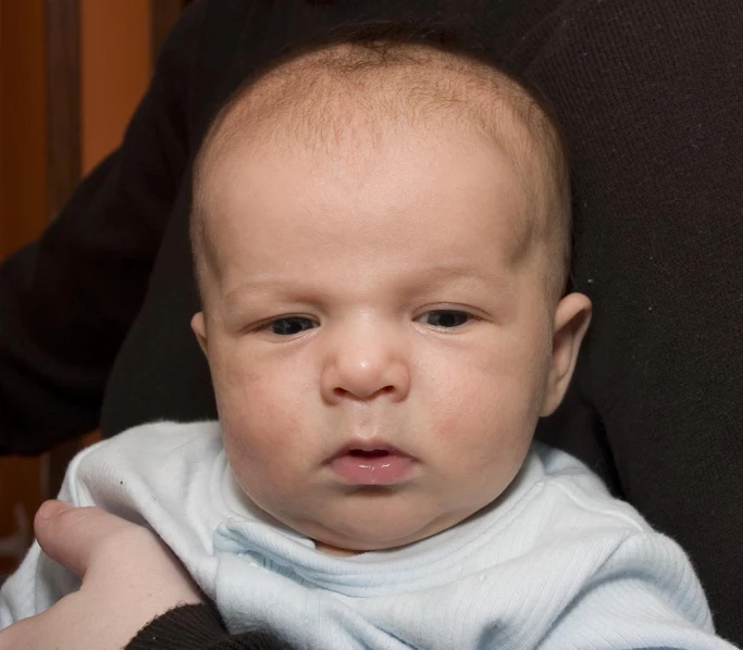 a baby looking sad, with the mouth open