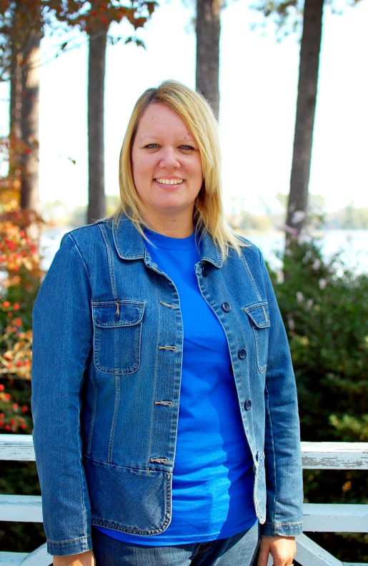 woman in blue shirt and jean jacket on bench