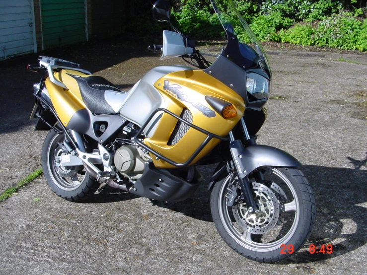 the motorcycle is shiny yellow and silver with black accents