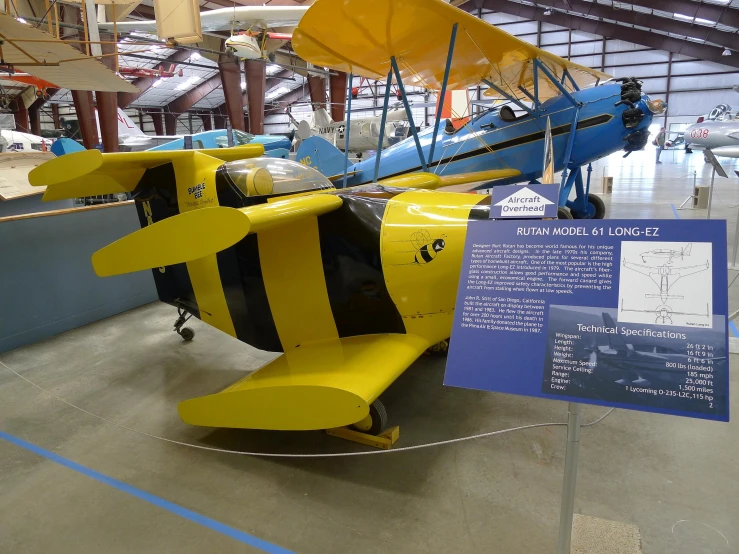 a yellow and blue airplane sits on display at an airport