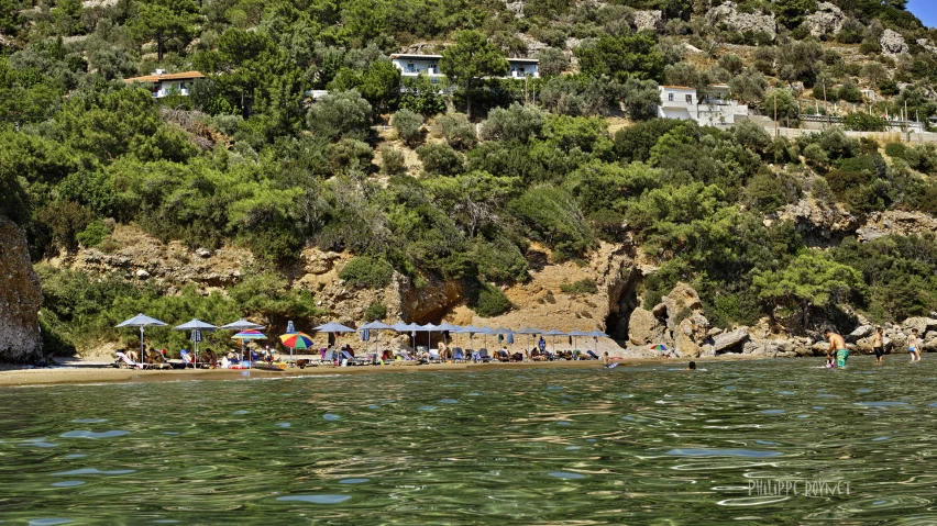 some people are sitting on a beach with their umbrellas