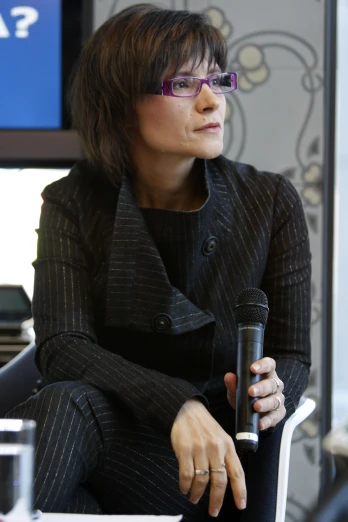 a woman sitting in front of a microphone