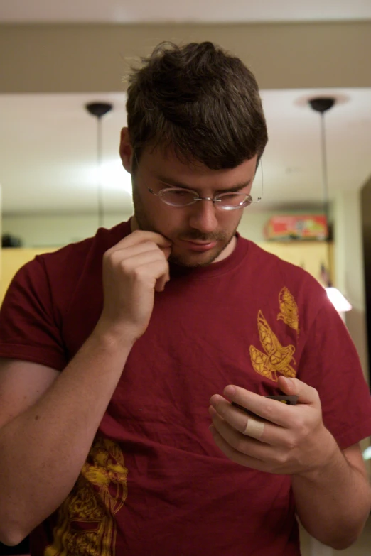 man standing in a living room checking his cellphone