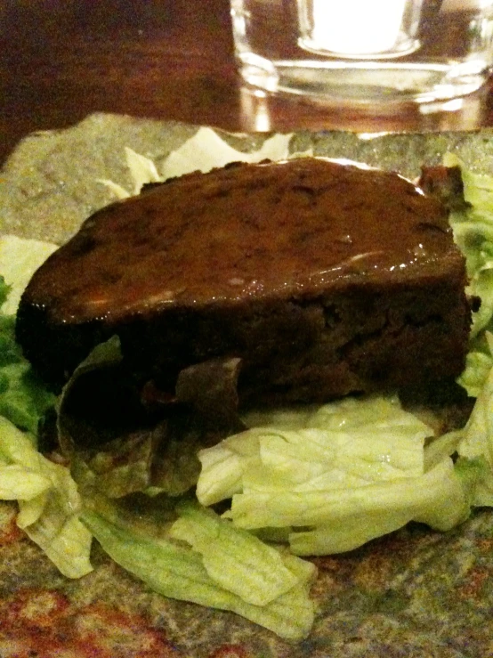 a steak sandwich is prepared with lettuce and sauce