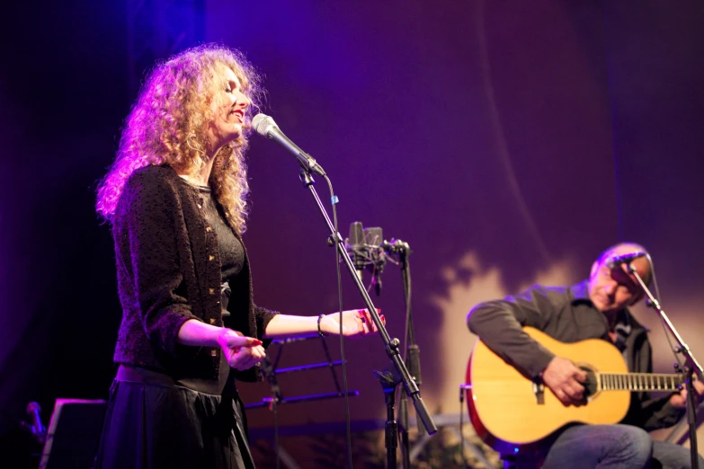 a woman that is standing up with a guitar