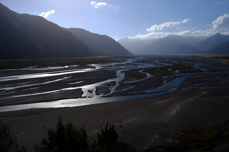 mountains are shown in the background while there is a river that flows