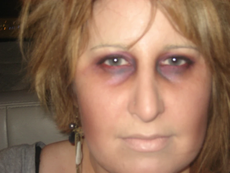 a woman with very large pink eyes has a creepy look on her face