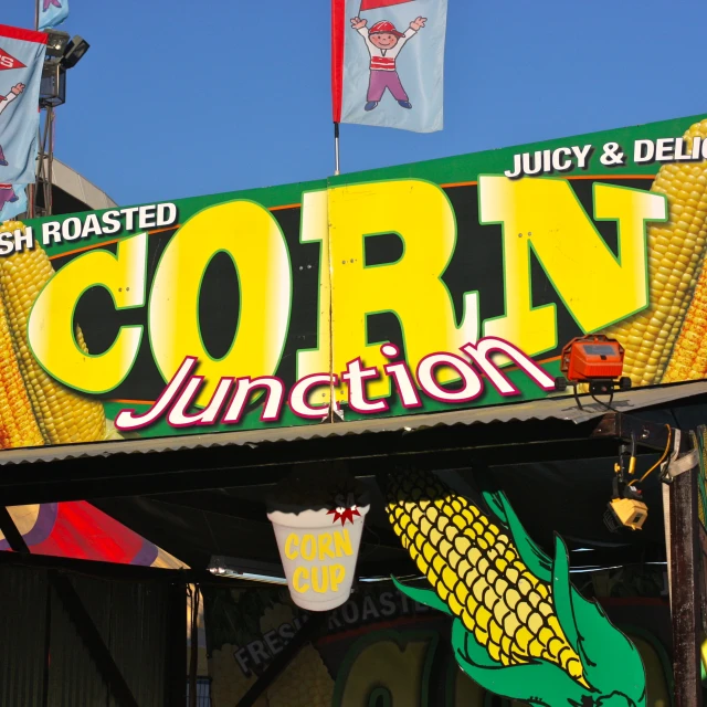 corn junction sign in an intersection with flags flying around it