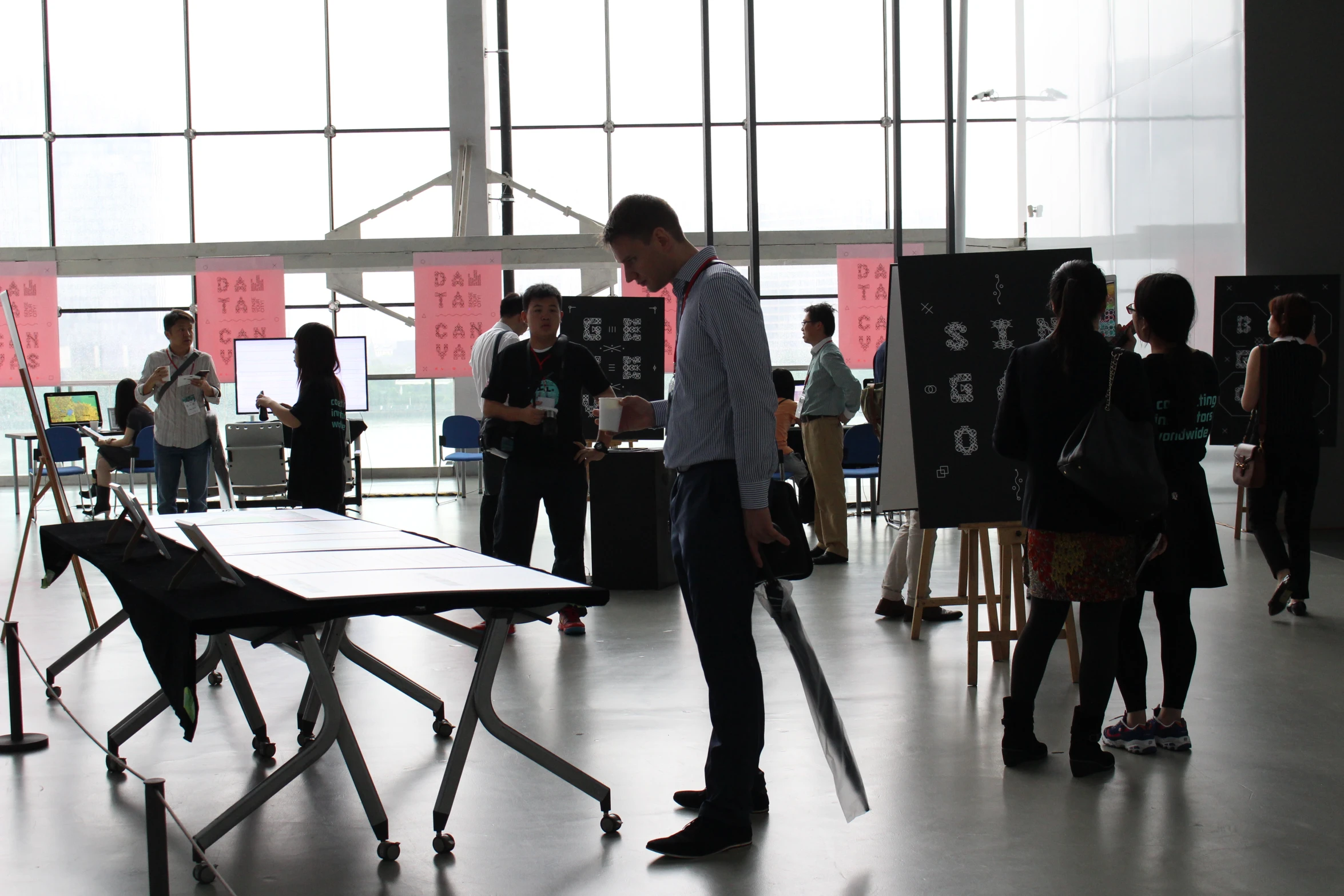 a man stands next to a table as others look at it