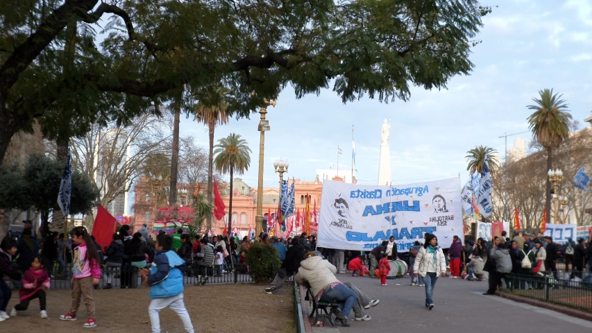 several people are standing with signs in a plaza