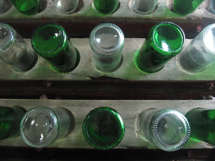 four rows of green empty wine bottles sitting on top of each other