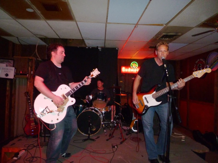 a group of men playing guitars and singing on stage