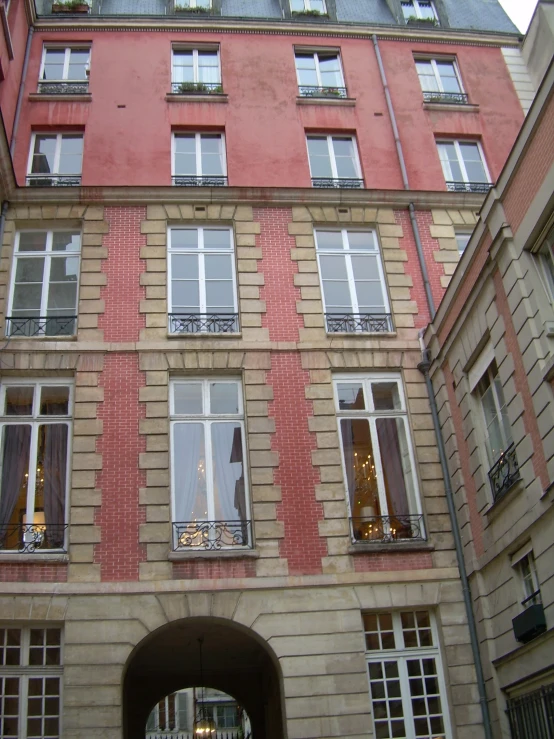 a building has two large windows and two cars passing by