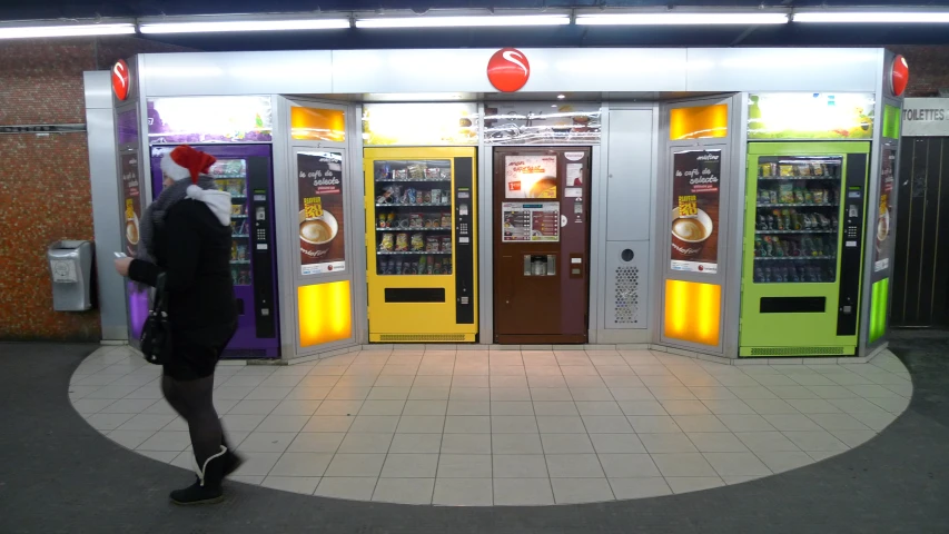 a woman in black standing next to some vending machines