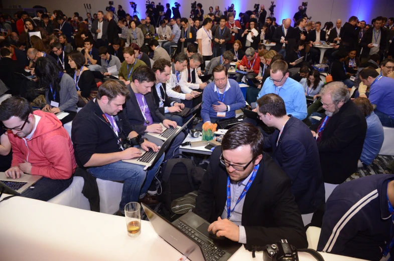 a large group of people in a room with computers