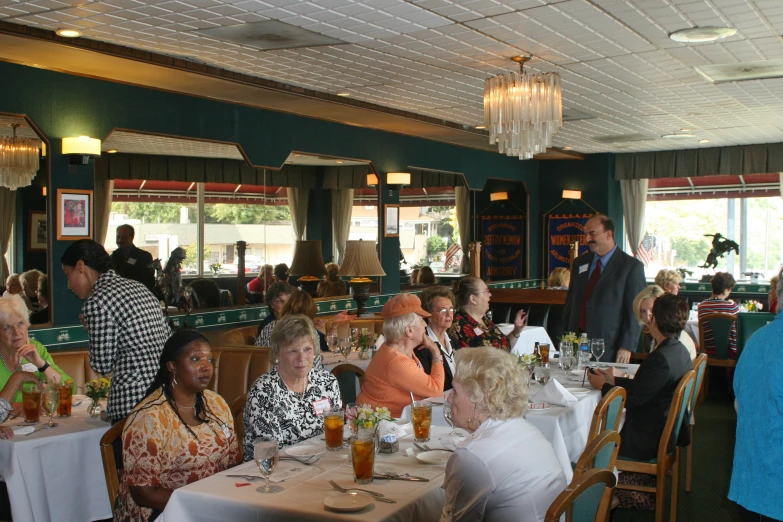 many people are sitting around at dinner tables