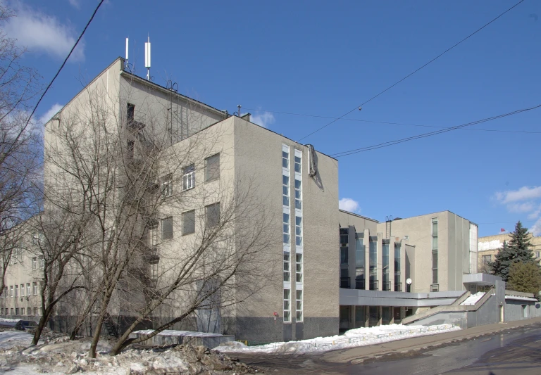 the building has two floors and is surrounded by trees