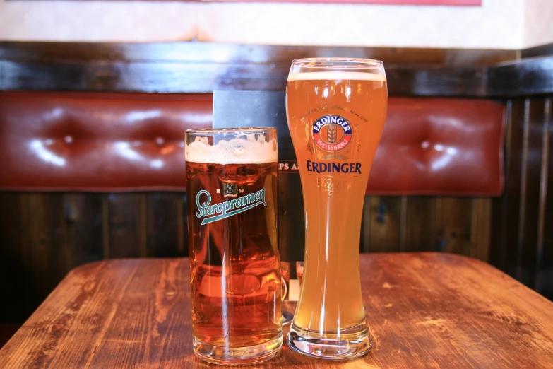 a wooden table with two beer mugs on it