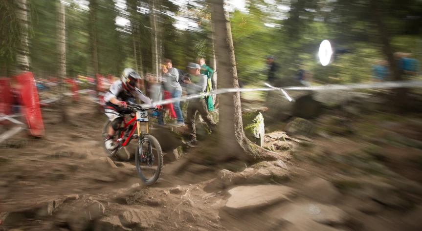 a man riding a dirt bike while people watch