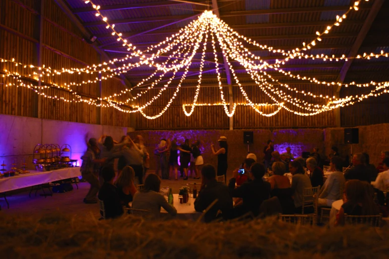 a tent covered in christmas lights and people talking