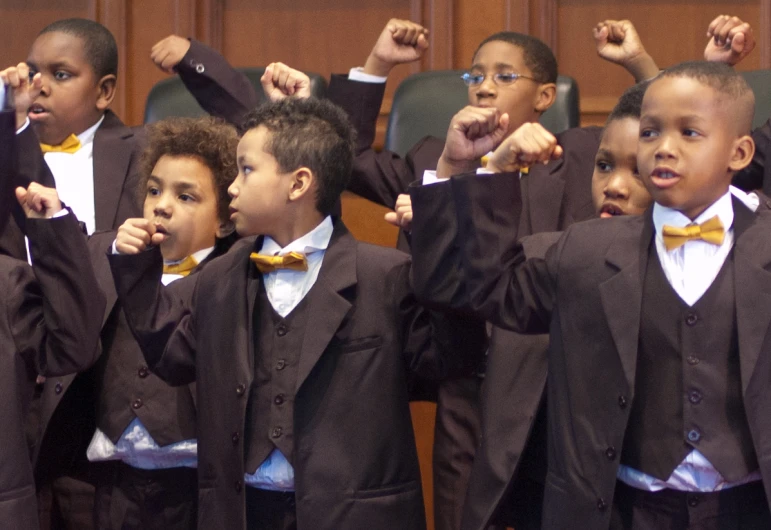 some children are posing for a picture and posing with their hands up