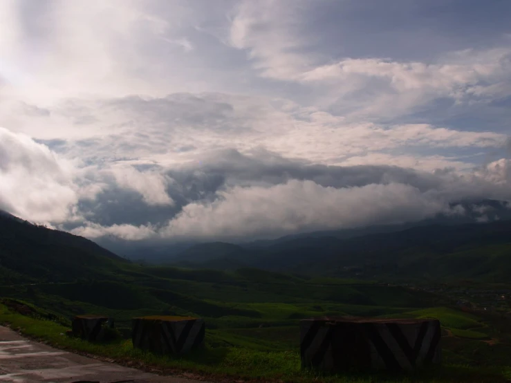 the road is going down near a lush green mountain