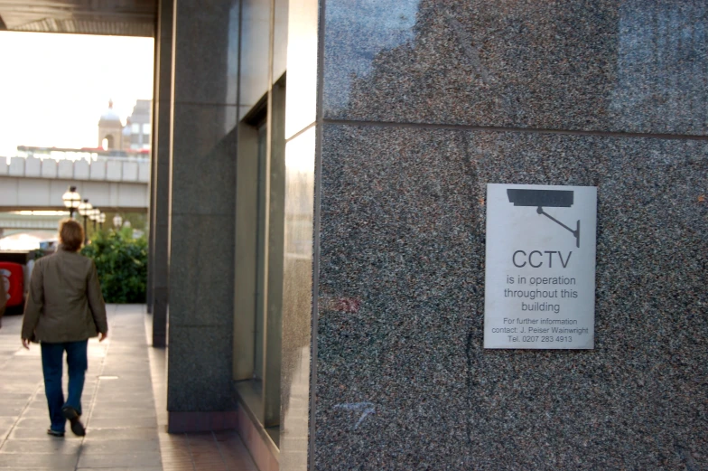 a woman walks on a sidewalk by some buildings