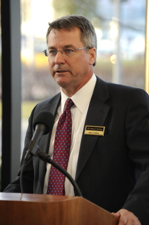 a man speaking at a podium with a microphone