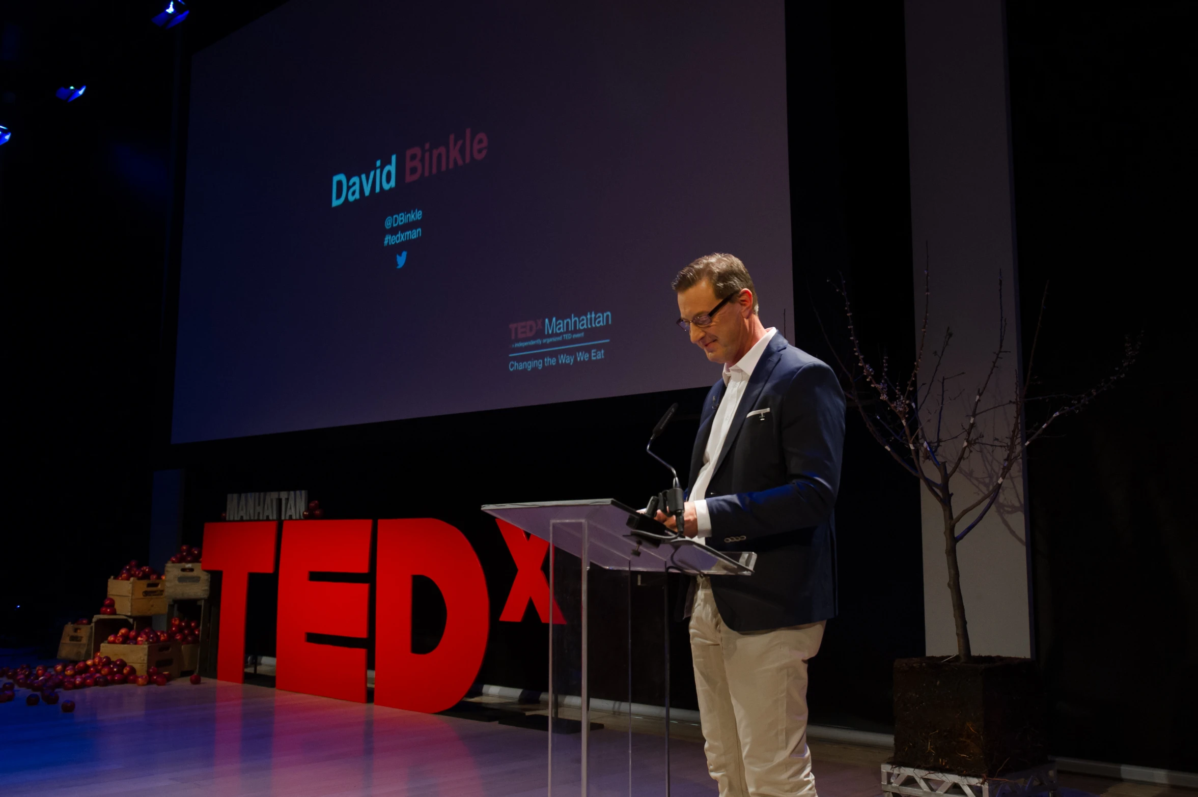 a man standing at a podium on stage speaking