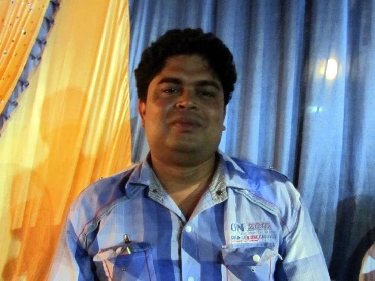 a man in a blue striped shirt poses for the camera