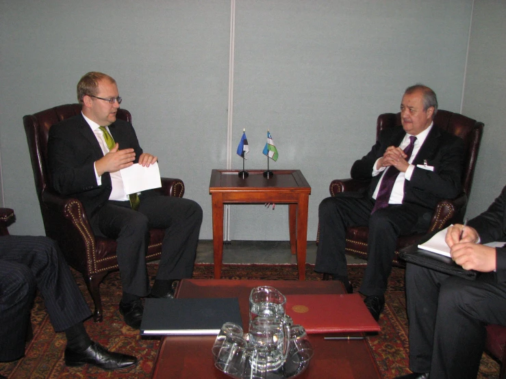 three men sitting next to each other talking