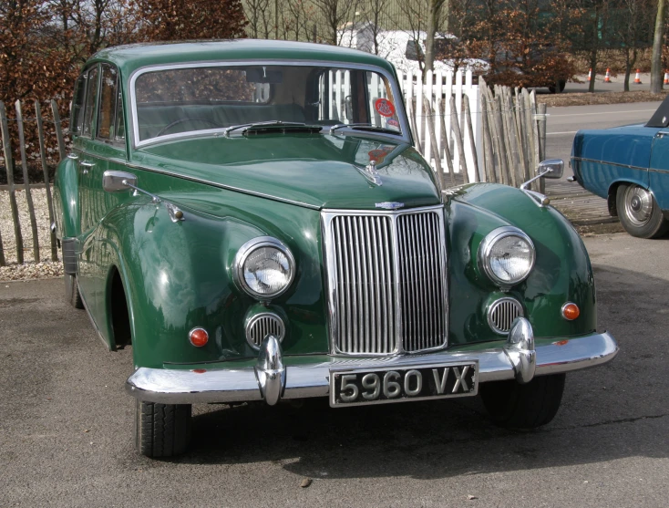 a very large green car parked in the street