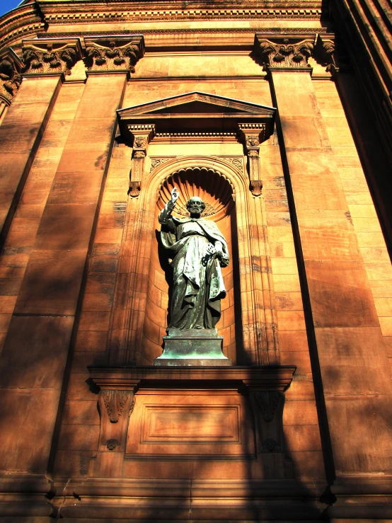 a large tall building with a statue on the side