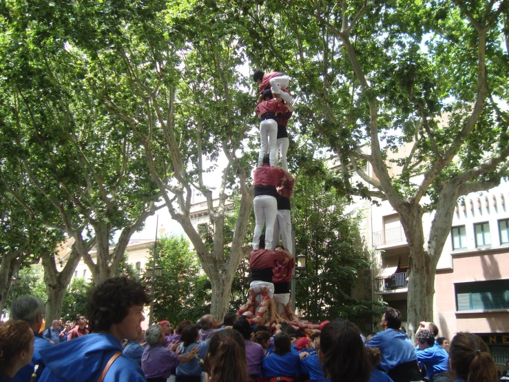some people standing and some trees and a person dressed as a cheerleader