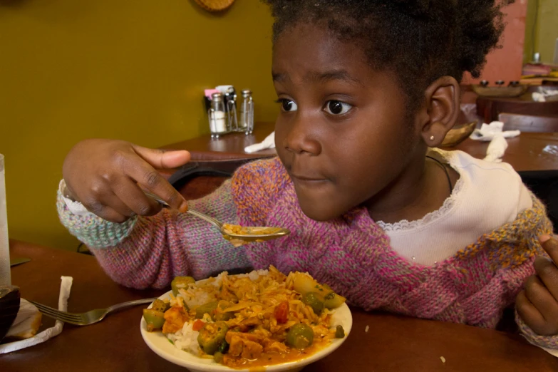 an african american girl eating dinner at a restaurant