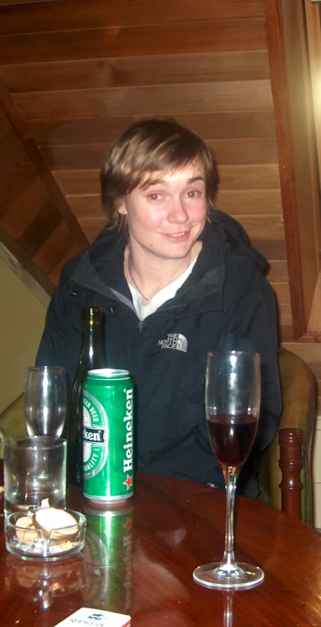 a man sits at a table with glasses and wine