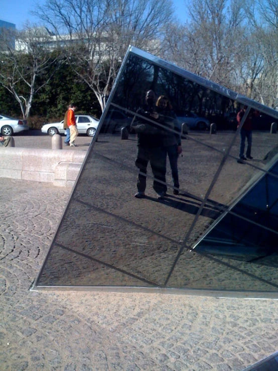 a person is walking past a large mirror