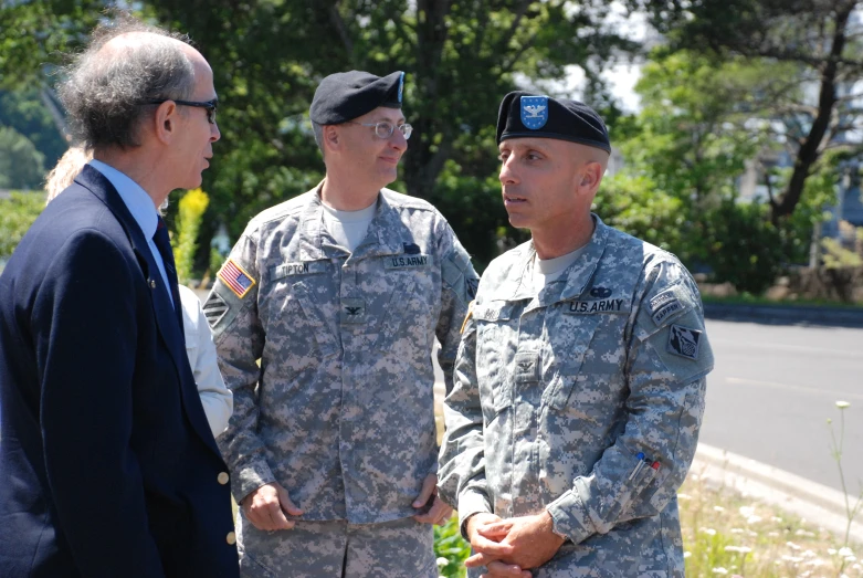 some military men in uniforms are standing near one another