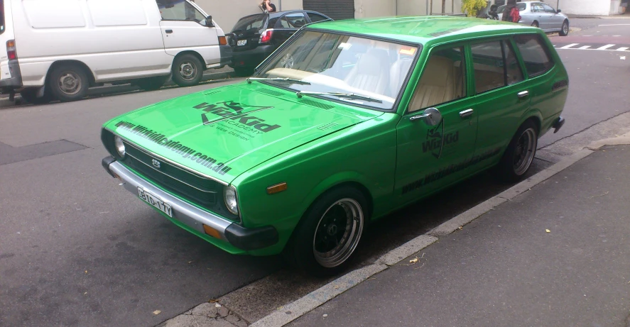 a green car parked on the side of a road