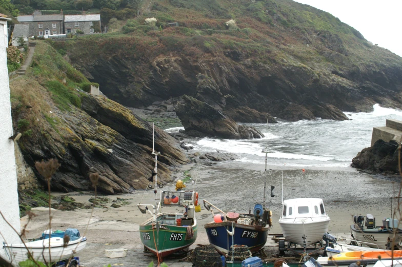 boats are sitting on the sand and beside the ocean