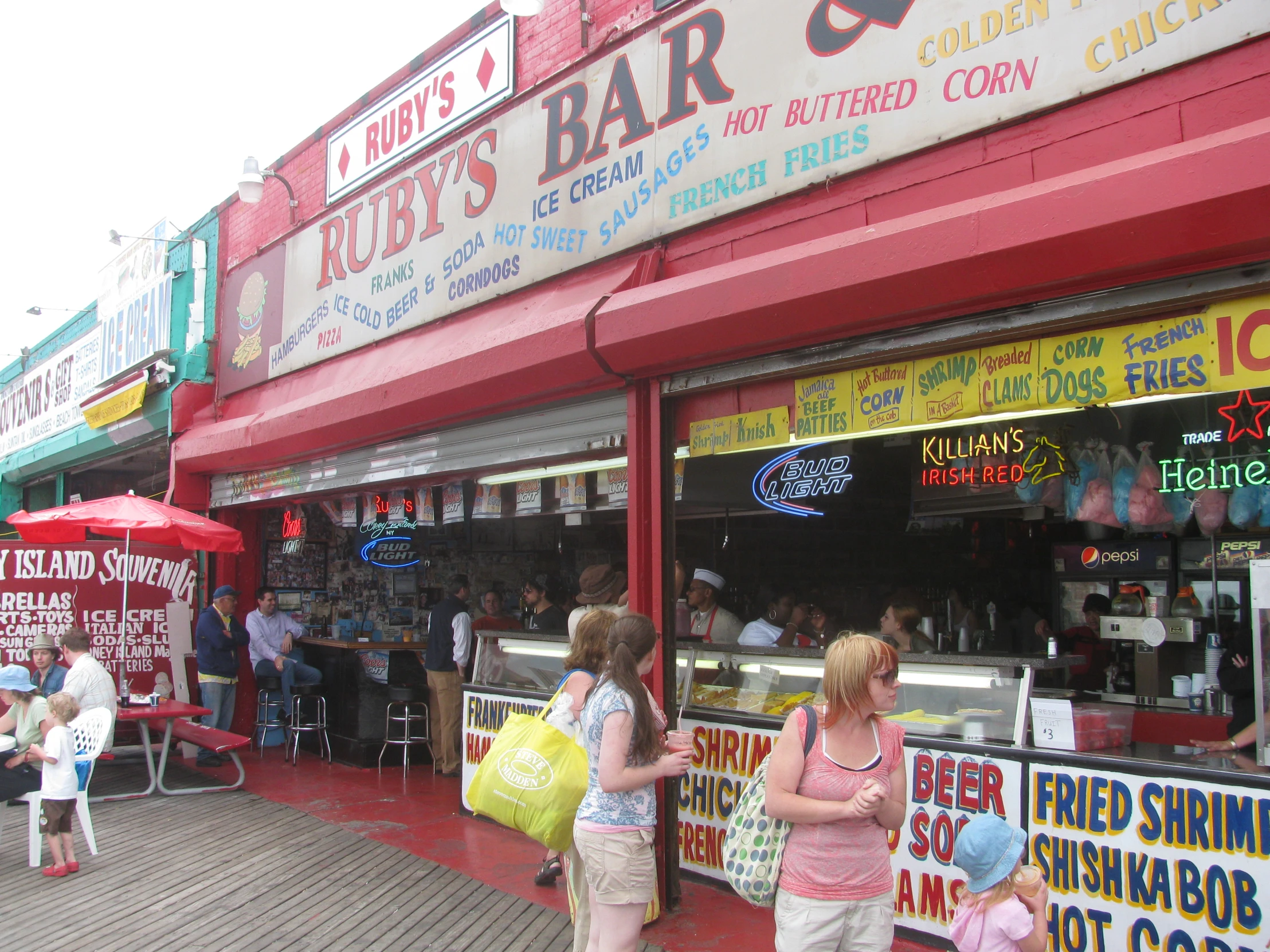 people standing outside a restaurant while others eat out